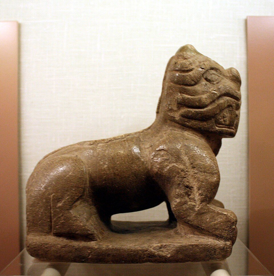 Carved stone feline figure from Moundville, seen in profile in a museum case