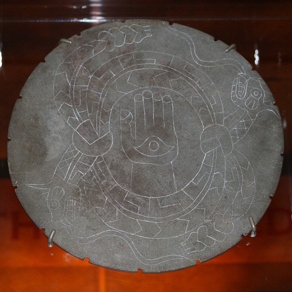 Engraved stone disc from Moundville showing a hand with an eye, ringed by two serpents