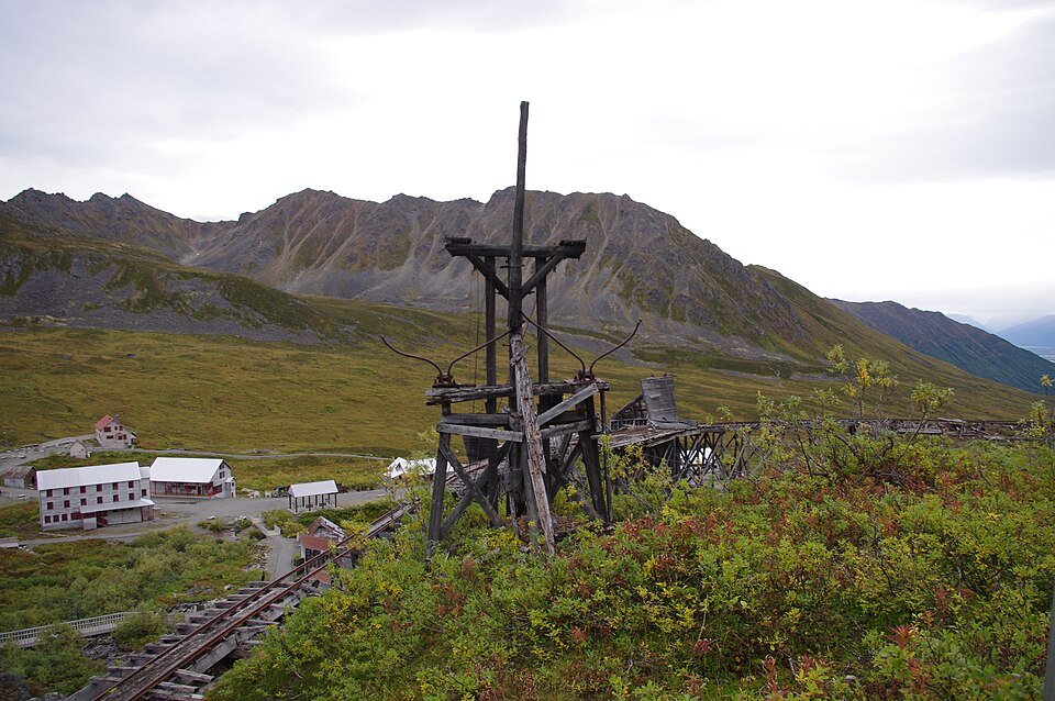 Wooden tram tower remains above the Independence Mine buildings in summer, with mountains behind