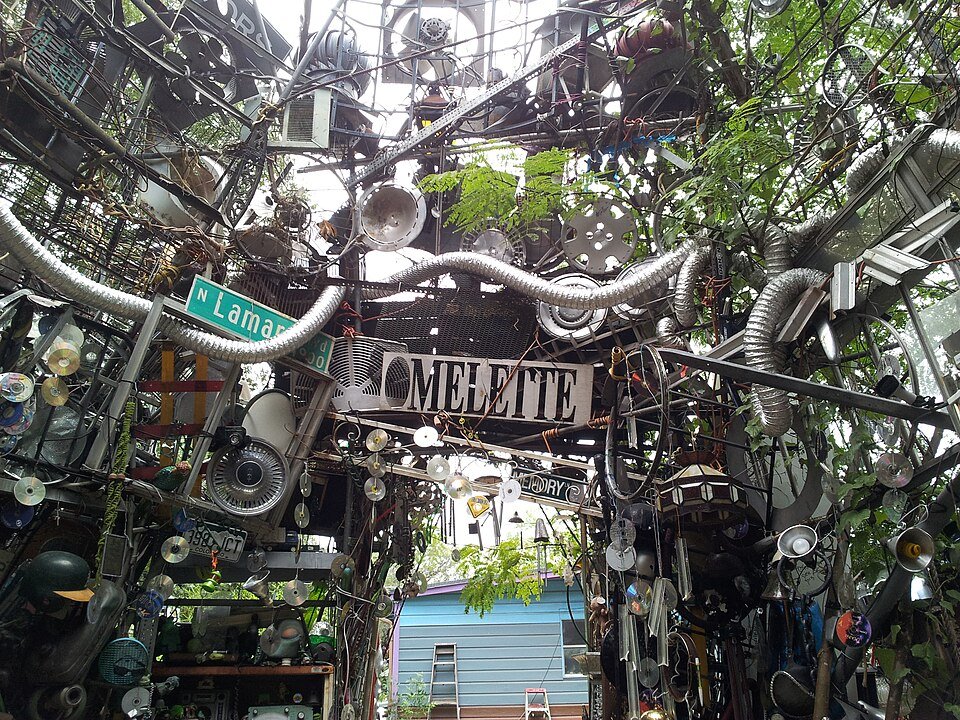 Mirando hacia arriba dentro de la Cathedral of Junk: ductos, tapacubos y letreros de calle
