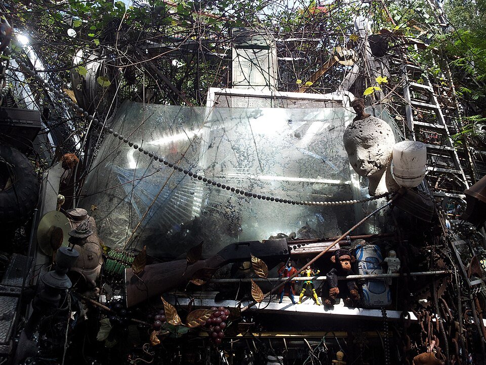 Un panel de vidrio recuperado y figuritas entre el entramado de la Cathedral of Junk