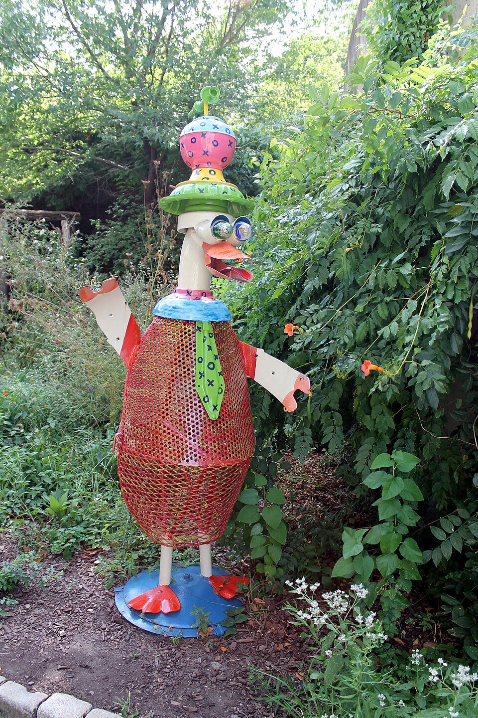 A colorful sculpture of a duck made from recycled parts in the museum's garden