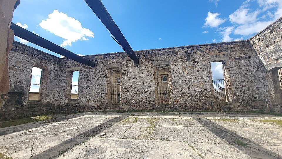 El casco de piedra quemado de la antigua capilla, abierto al cielo y con vigas chamuscadas
