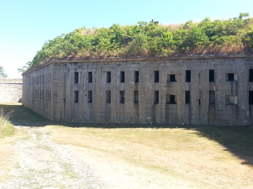 A granite flank wall of Fort Warren with openings along its face
