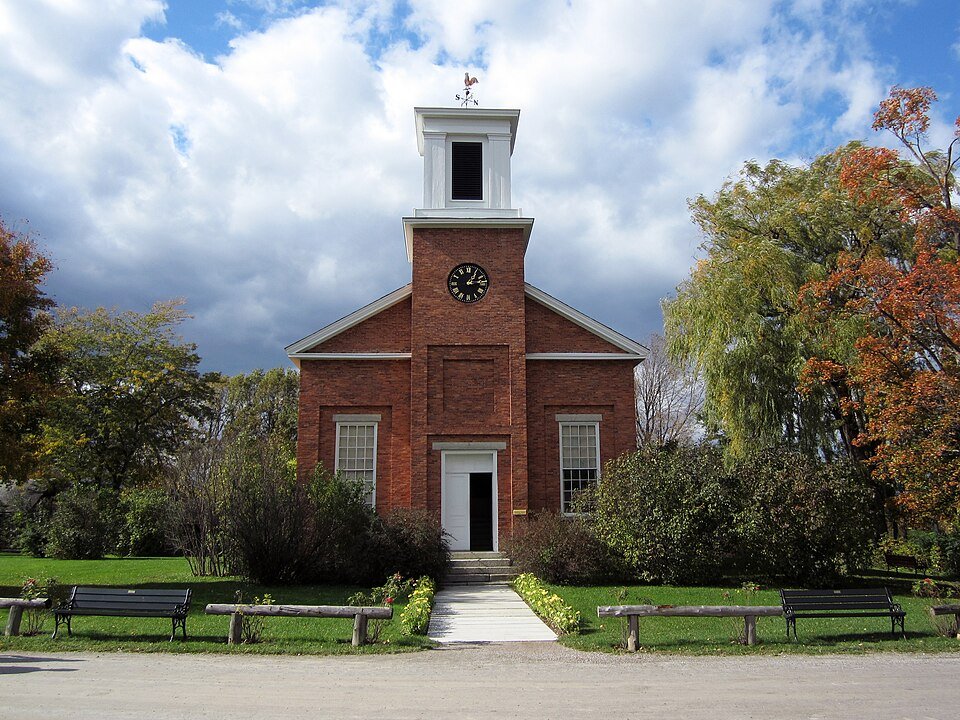 Charlotte Meeting House, a brick building with a clock and a white bell tower