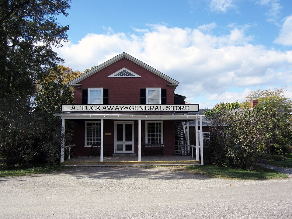 Tuckaway General Store, a red brick building with a covered porch and a painted sign