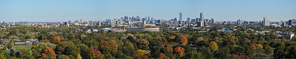 Boston skyline over autumn trees, seen from Mount Auburn in a wide panorama