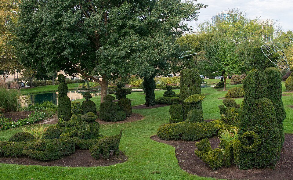 Figuras de topiario y un estanque entre árboles en Topiary Park