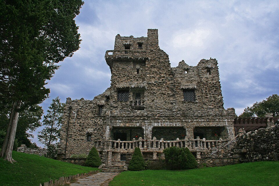 Front of Gillette Castle, built of rough local stone, with a porch and balustrade above a lawn