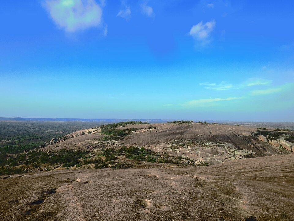 The bare granite summit of Enchanted Rock, with the Texas Hill Country stretching to the horizon
