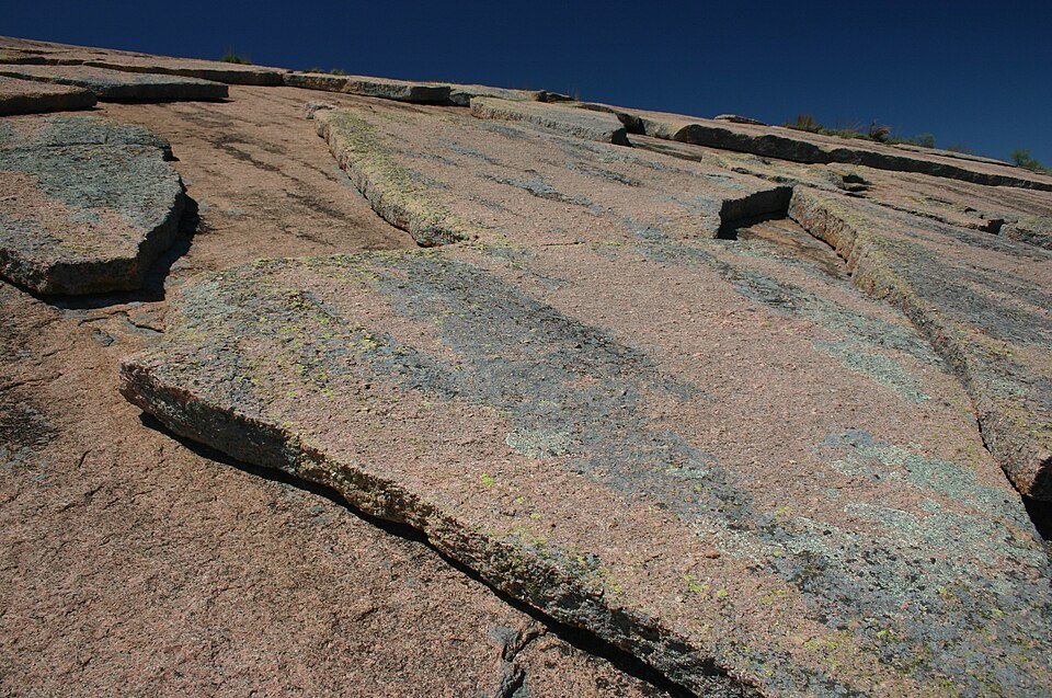 Sheets of pink granite peeling away from the dome, with patches of lichen