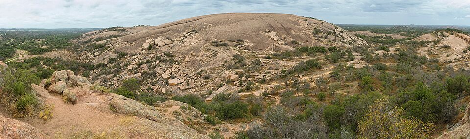 Panoramic view of the main dome of Enchanted Rock above scrubland and boulders