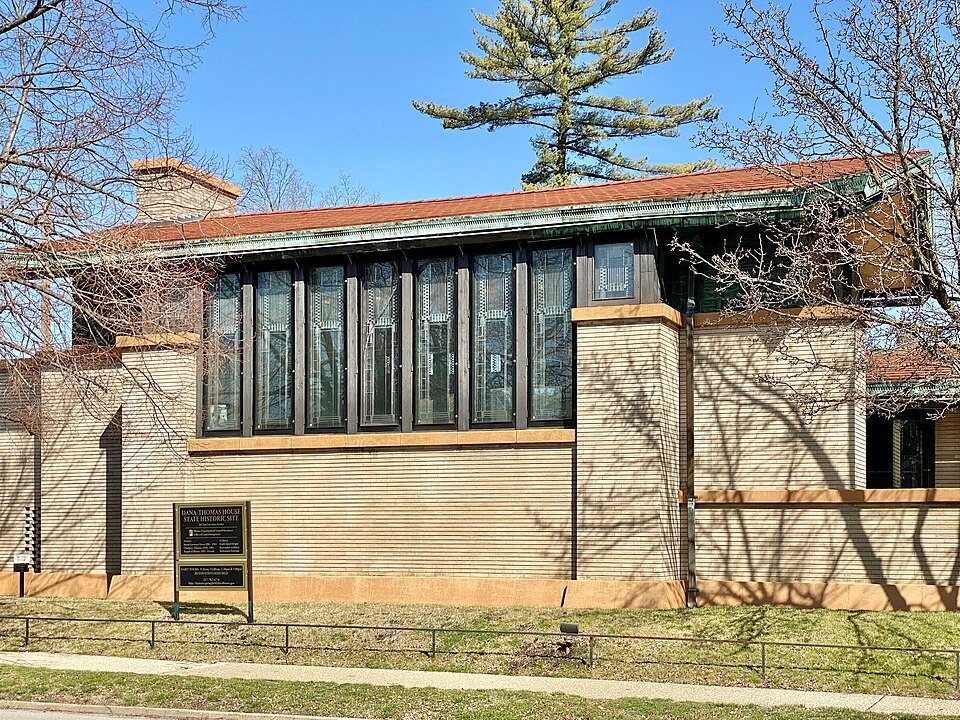 Side of the Dana-Thomas House with its row of tall art glass windows under a low roof