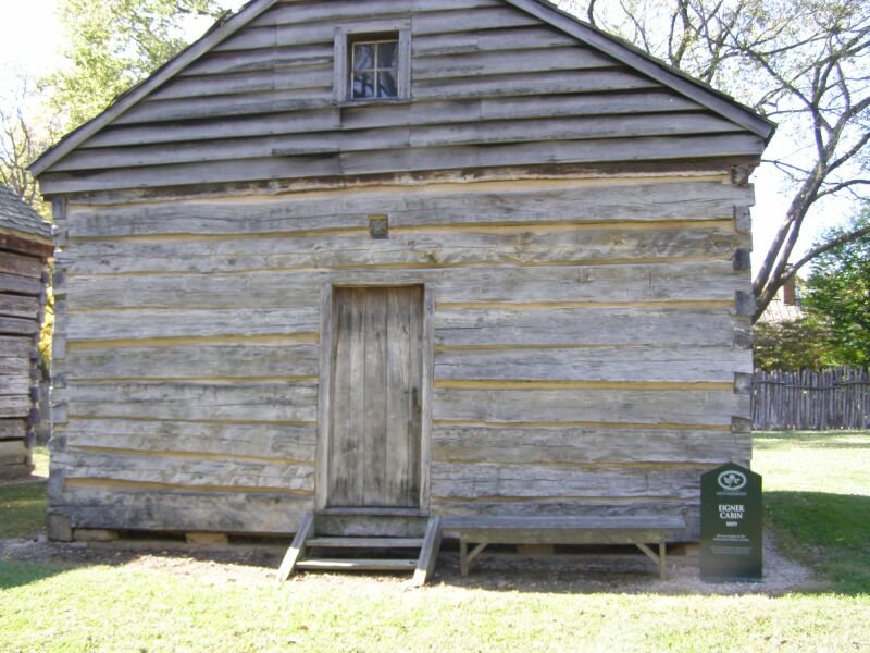 Eigner Cabin, a weathered log cabin with a plank door in New Harmony, Indiana