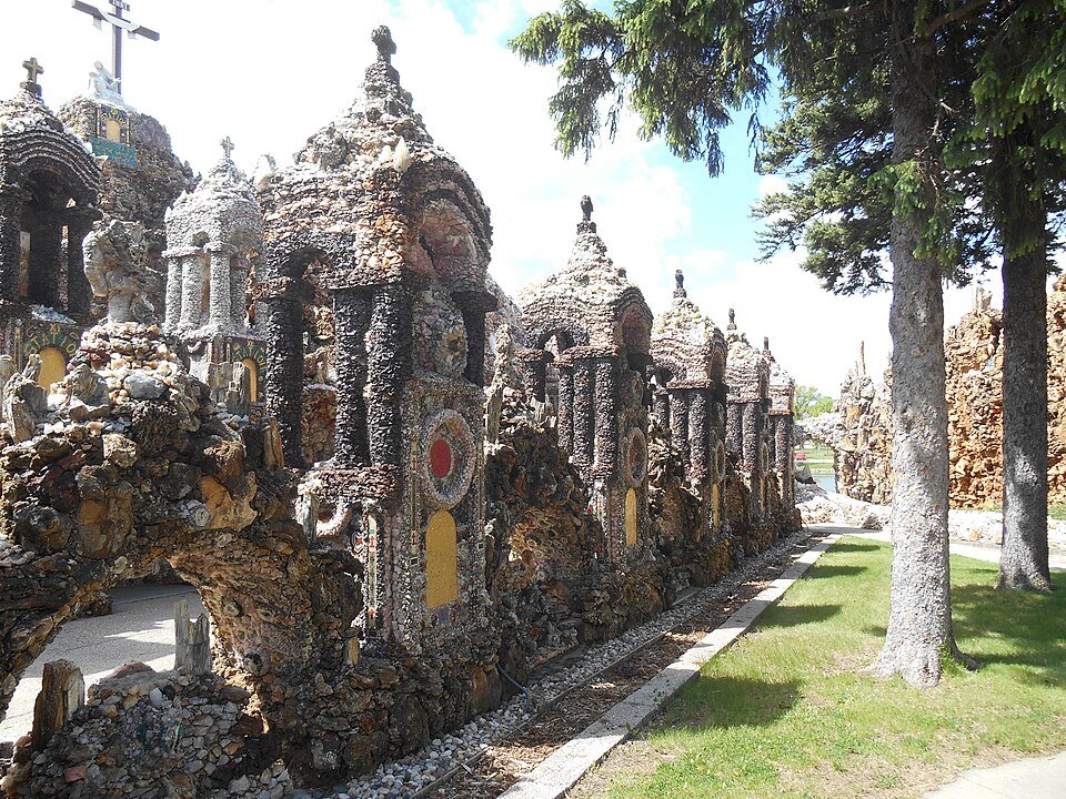 Una hilera de pequeños santuarios cubiertos de minerales junto a un sendero en la Grotto of the Redemption
