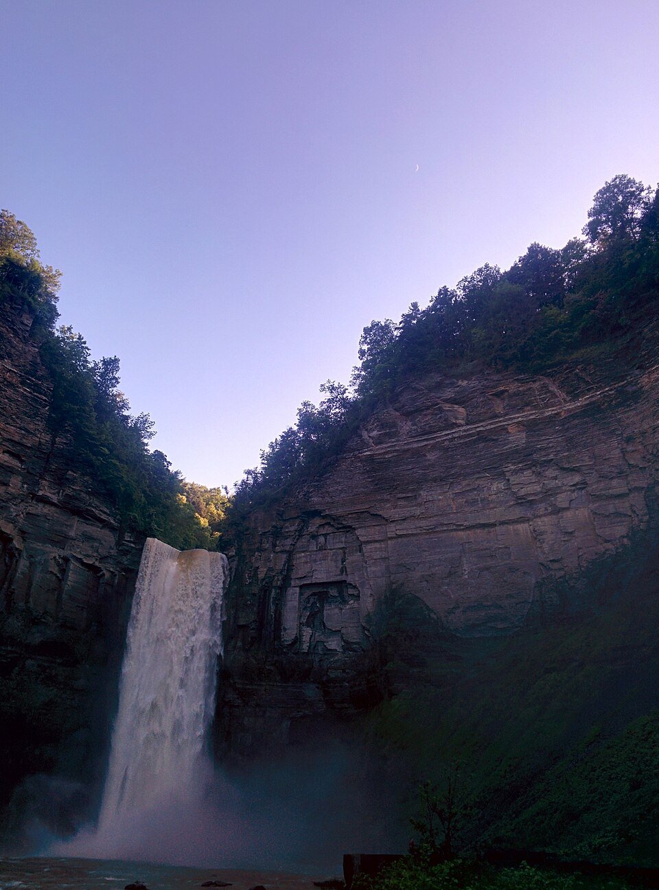 The main falls from the base of the gorge at dusk, with a crescent moon above the cliffs