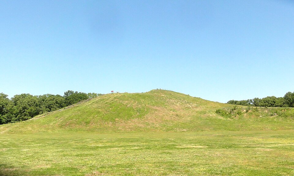 Mound A, the Bird Mound, a tall grassy mound rising above open ground at Poverty Point