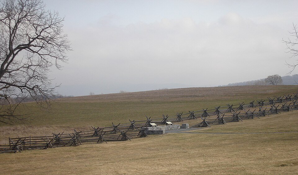 Zigzag split-rail fences and a marker across the open fields along the Bloody Lane at Antietam