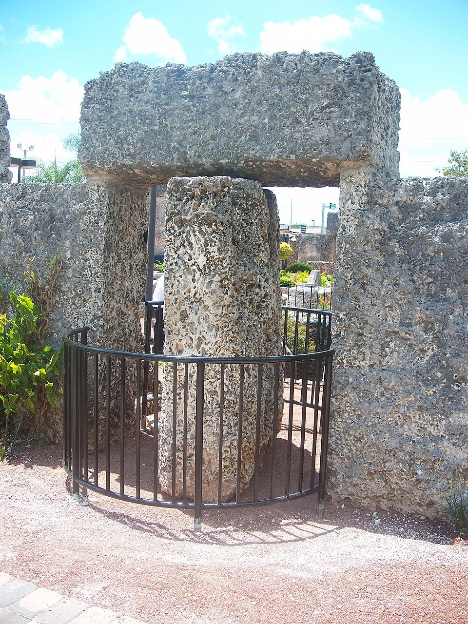 A área do portão giratório em Coral Castle, com um poste de pedra dentro de uma grade