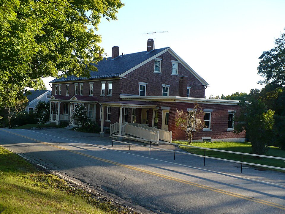 The Trustees Office at Canterbury Shaker Village, a brick building beside the road