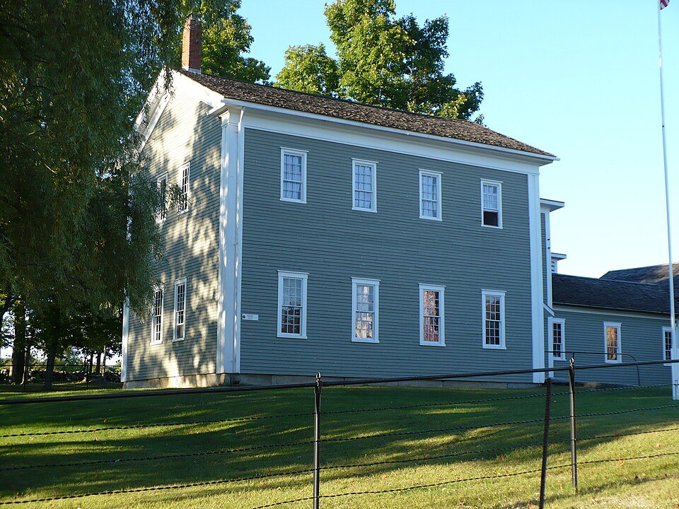 The School House at Canterbury Shaker Village, a gray-green clapboard building with white trim
