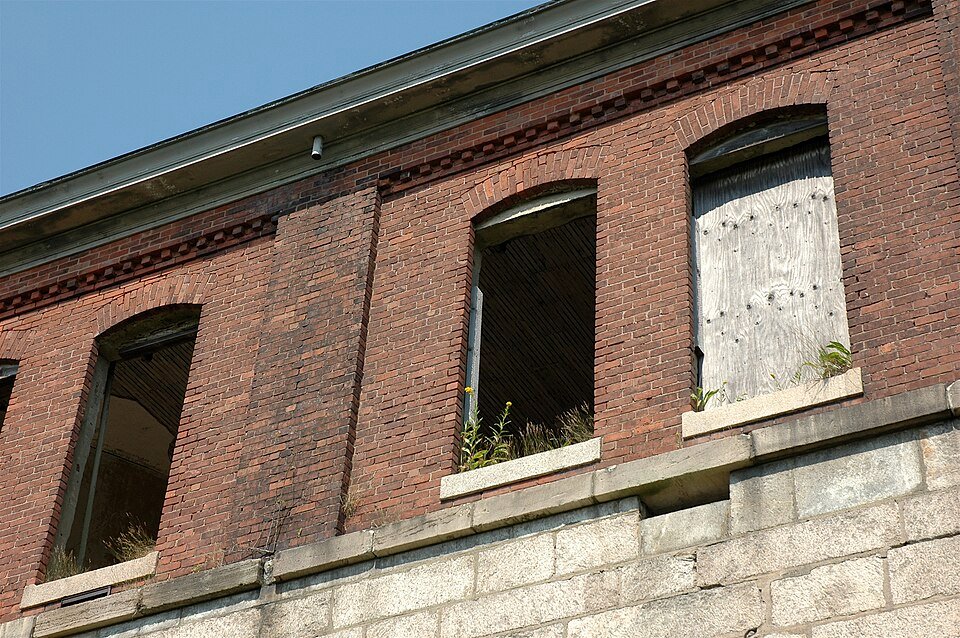 Janelas de tijolo, algumas tapadas, nas muralhas do Fort Adams