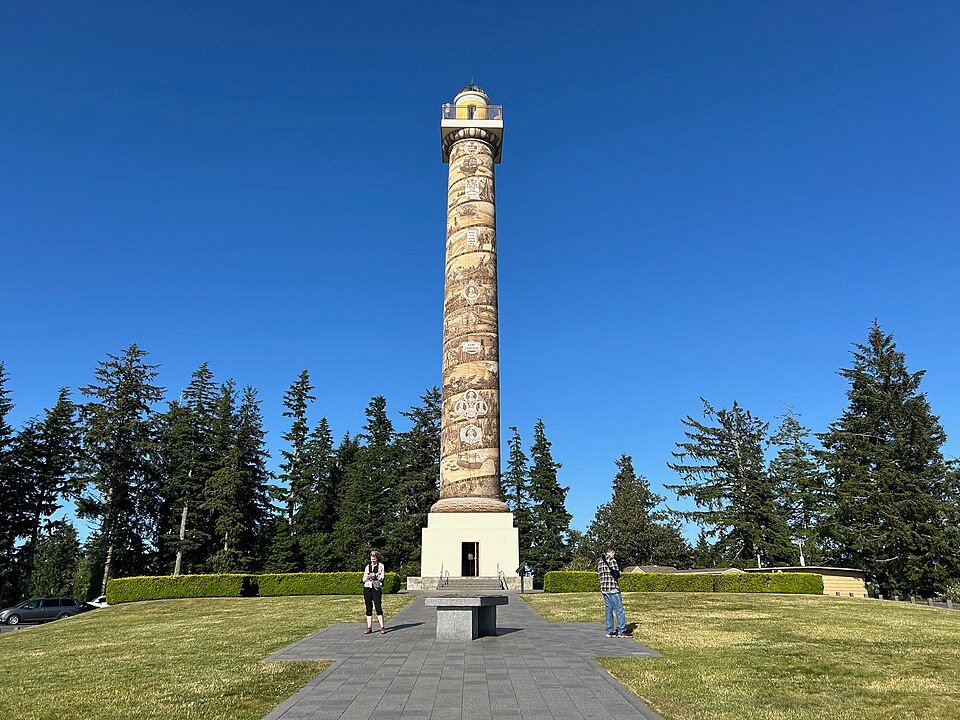 The Astoria Column on Coxcomb Hill, a tall tower with a spiral painted frieze, seen from the paved plaza