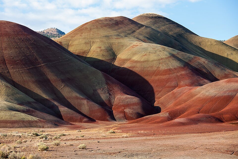Close view of the red, tan and olive layered slopes of the Painted Hills in late light