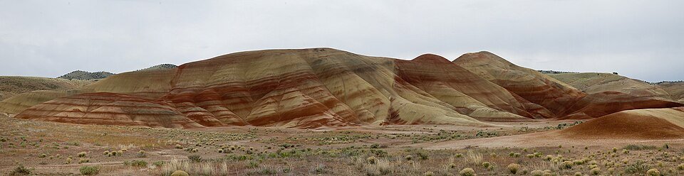 Panoramic view of the banded red and tan Painted Hills under an overcast sky