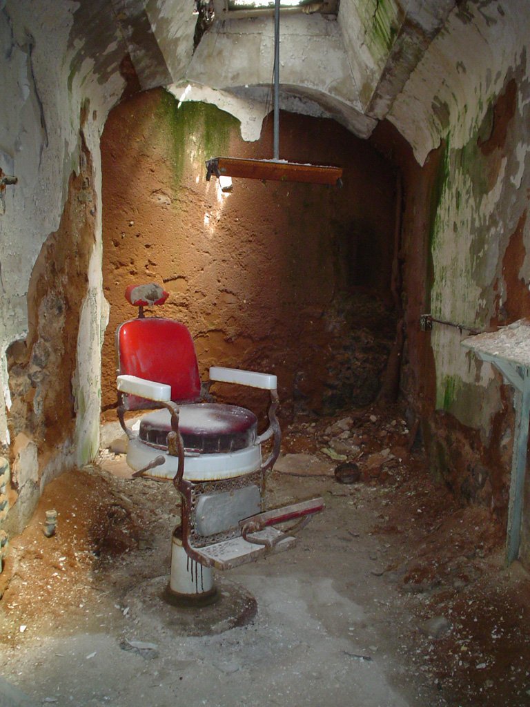 A barber chair in a decayed room at Eastern State Penitentiary