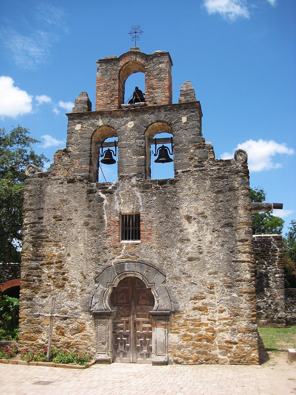 A fachada de pedra e a espadana da igreja da Mission Espada