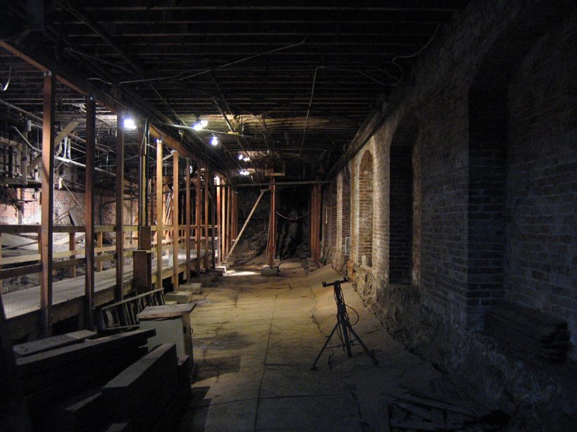 A long brick-walled passage with wooden supports in the Seattle Underground