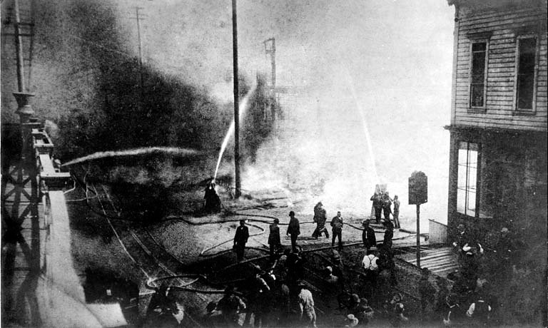 The Great Seattle Fire of 1889, with firefighters and hoses in a historic photograph