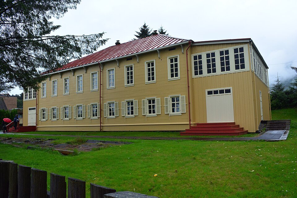The gabled end and gallery of the Russian Bishop’s House, with a white door and red steps, on a rainy day