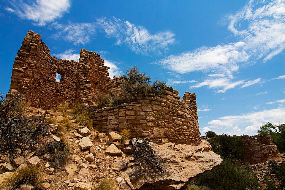 Stone ruins of the Cutthroat Castle group at Hovenweep, with a curved wall in front