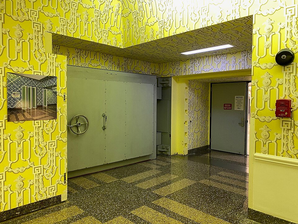 A gray blast door beside a yellow-wallpapered corridor at the entrance to the Greenbrier Bunker