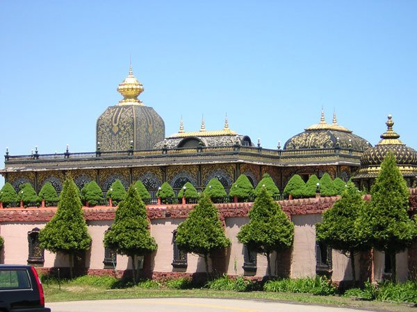 Cúpulas do Palace of Gold de Prabhupada acima de um muro e de coníferas aparadas, em New Vrindaban, na Virgínia Ocidental