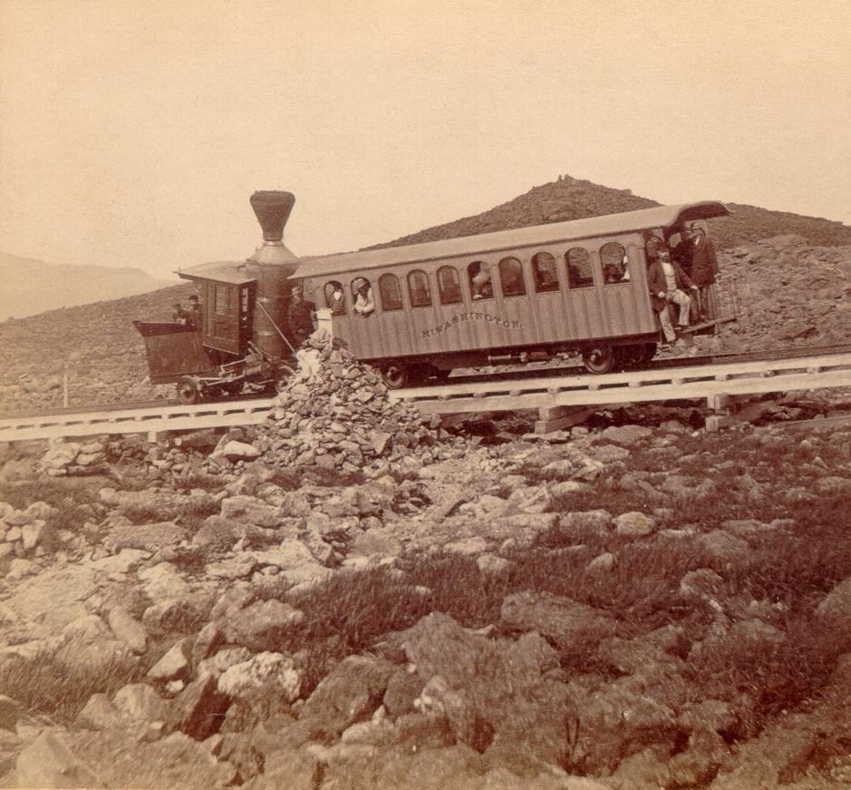 Uma locomotiva a vapor antiga e um vagão de passageiros na montanha, em uma fotografia do século XIX