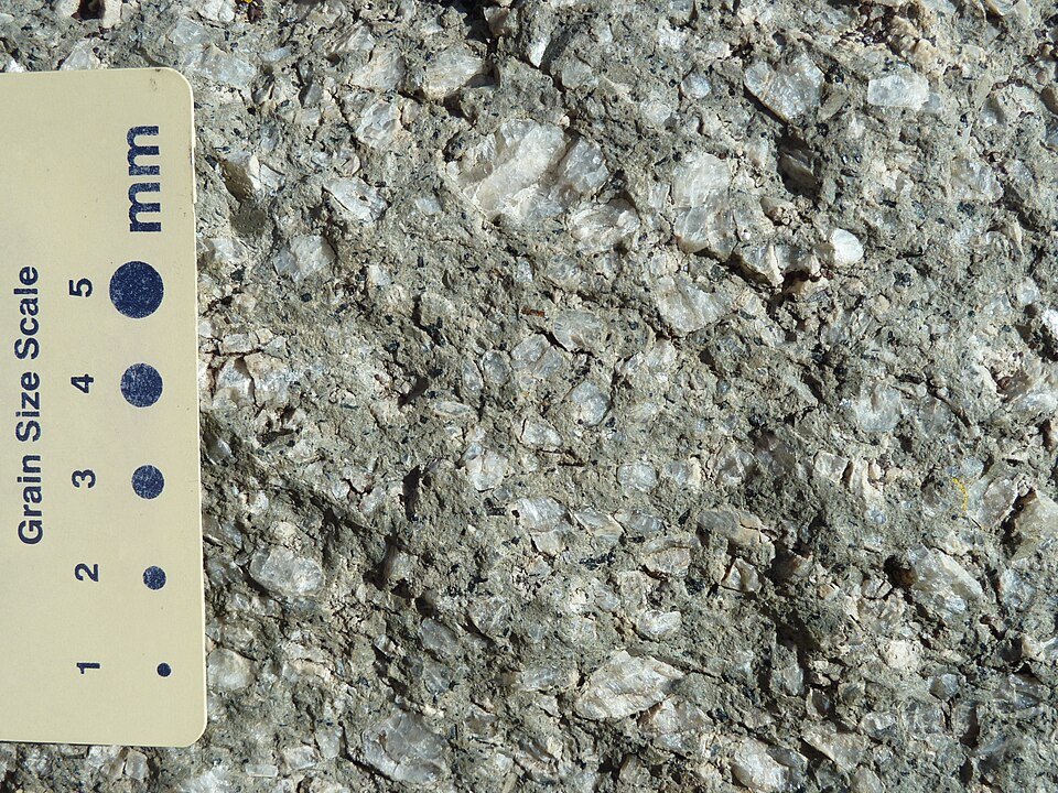 Close-up of phonolite porphyry from Devils Tower, with a grain-size scale card